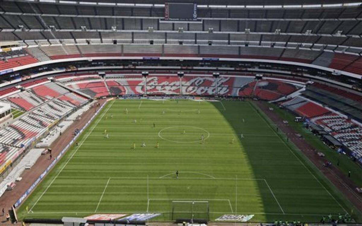 Aztec Stadium, one of the world's largest soccer stadiums, sits empty as America plays Tecos in a Mexican League soccer game in Mexico City, Mexico, Sunday, April 26, 2009. Public officials closed the stadiums to the public Sunday, and health workers screened airports and bus stations for people sickened by a new strain of swine flu that experts fear could become a global epidemic. (AP Photo/Gregory Bull)