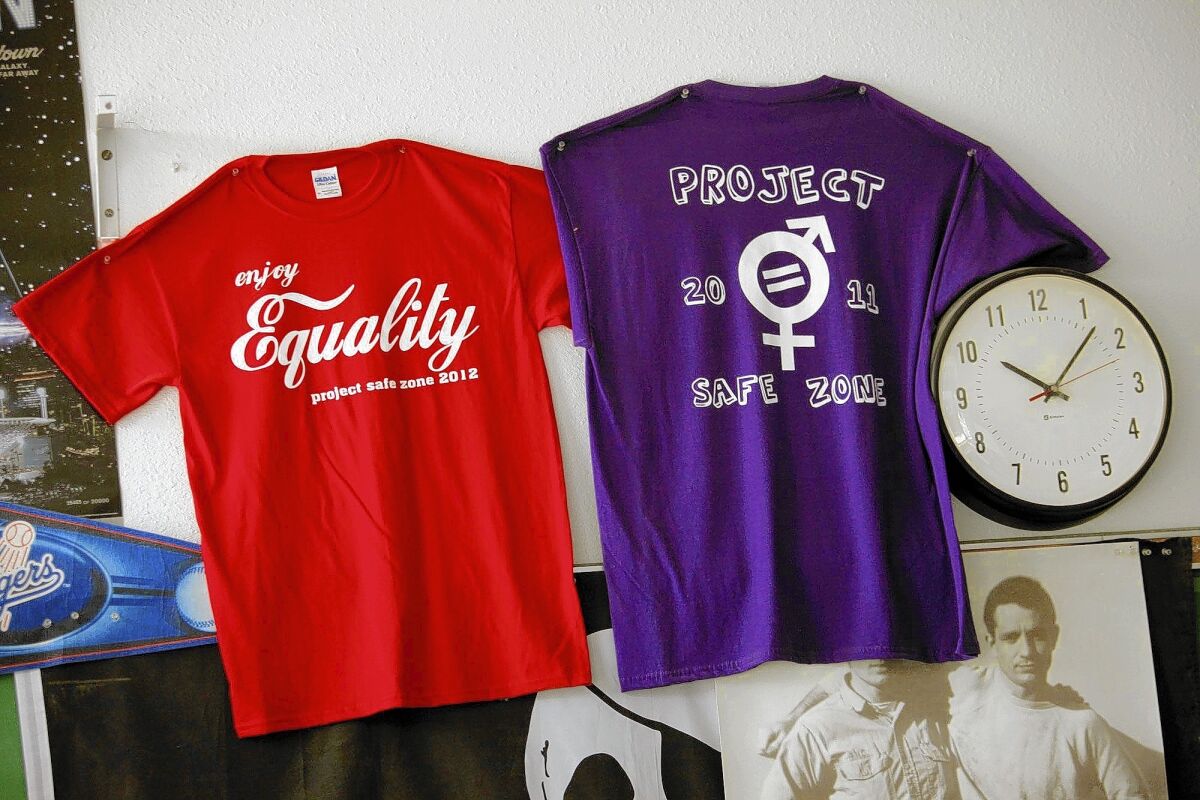 A pair of "Project Safe Zone" T-shirts pinned to a wall espouse equality.