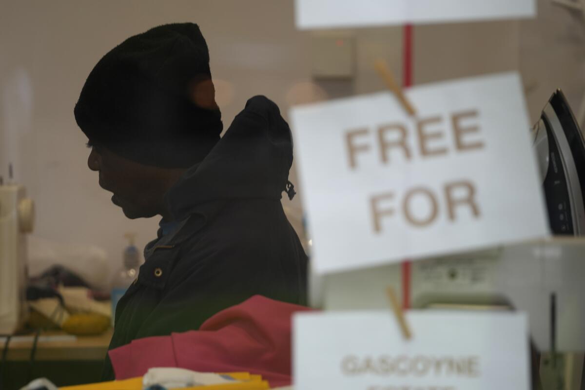 Silhouette of a man behind a small sign reading "Free For"