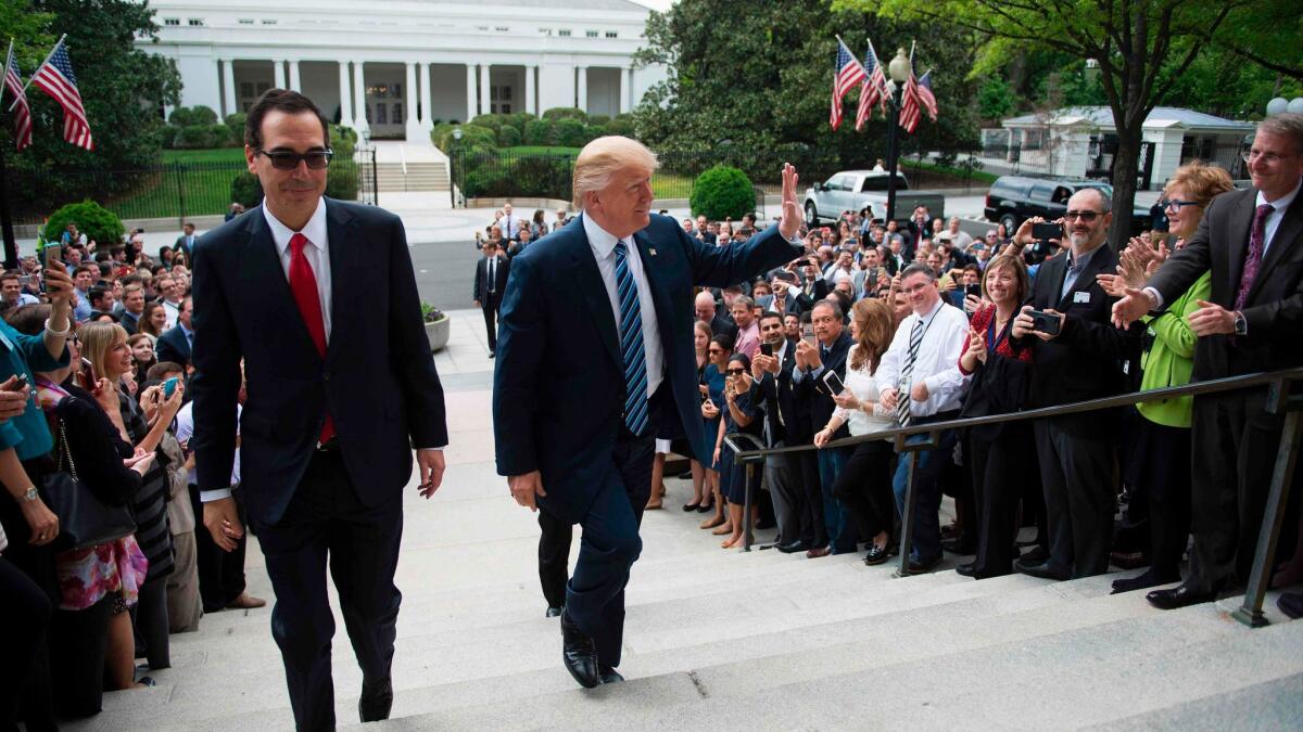 President Donald Trump waves with Treasury Secretary Steven Mnuchin as they walk from the White House to the Treasury Department in Washington, DC, April 21, 2017.