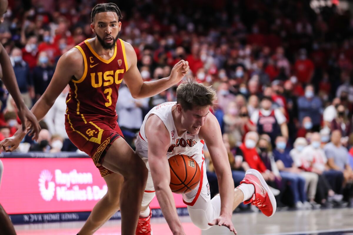 Arizona's Azuolas Tubelis tumbles in front of USC's Isaiah Mobley during the second half Feb. 5, 2022.