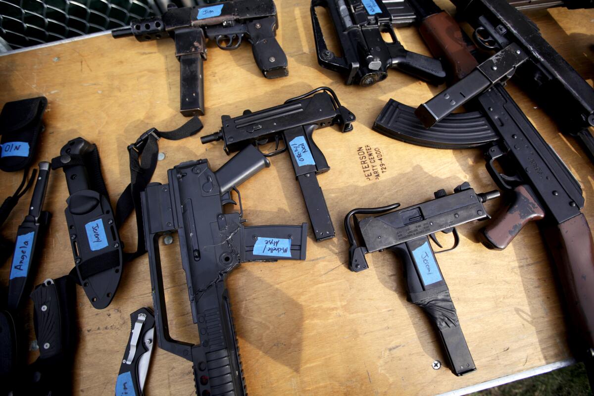 Real-looking gun props for a stage production of "Coriolanus" on a table.