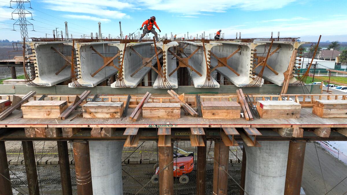 Workers stand on top of concrete structures.