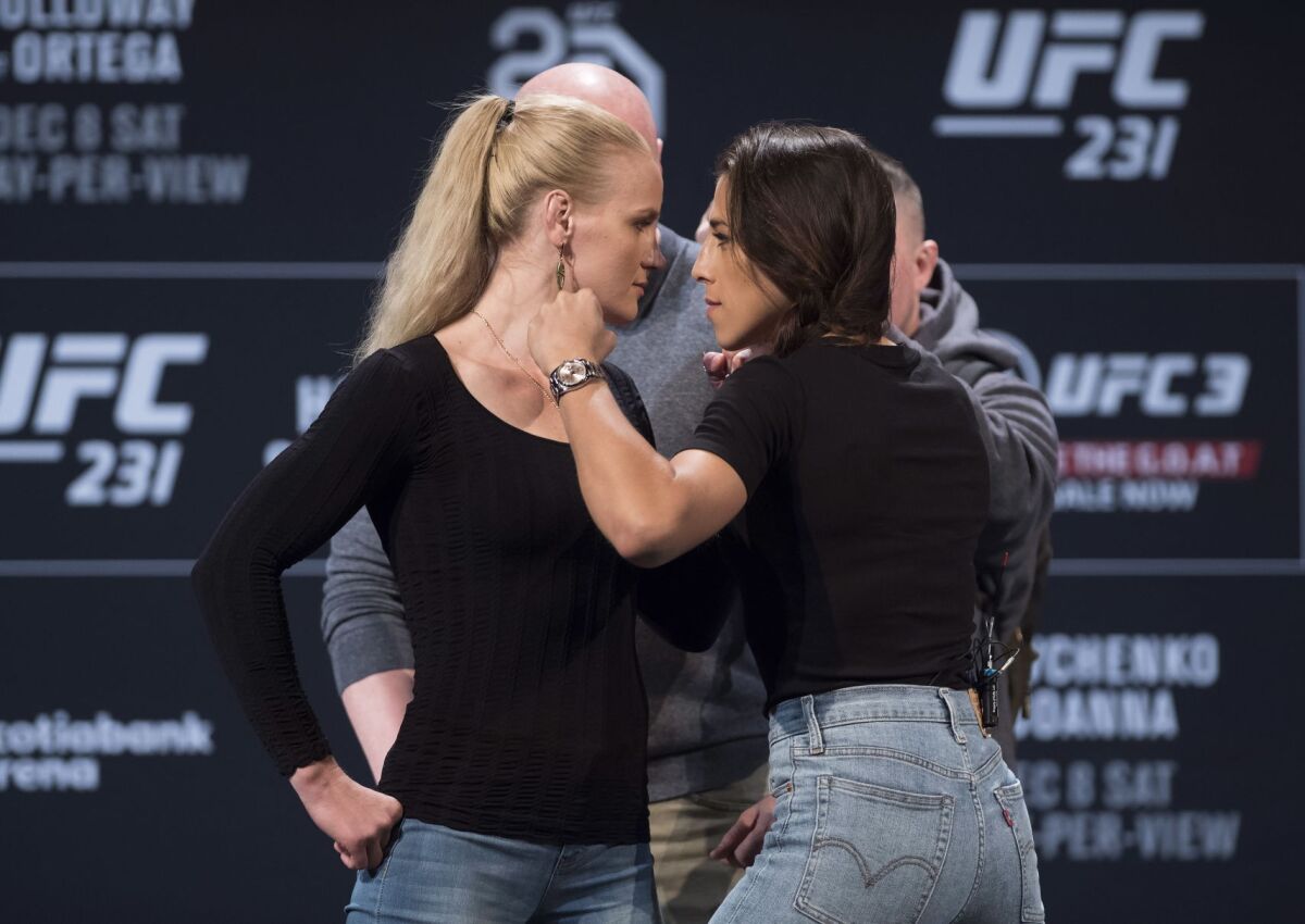 Valentina Shevchenko, left, UFC women's flyweight fighter and Joanna Jedrzejczyk UFC women's strawweight fighter face off at a news conference in Toronto on Wednesday, Dec. 5, 2018. (Nathan Denette/The Canadian Press via AP)