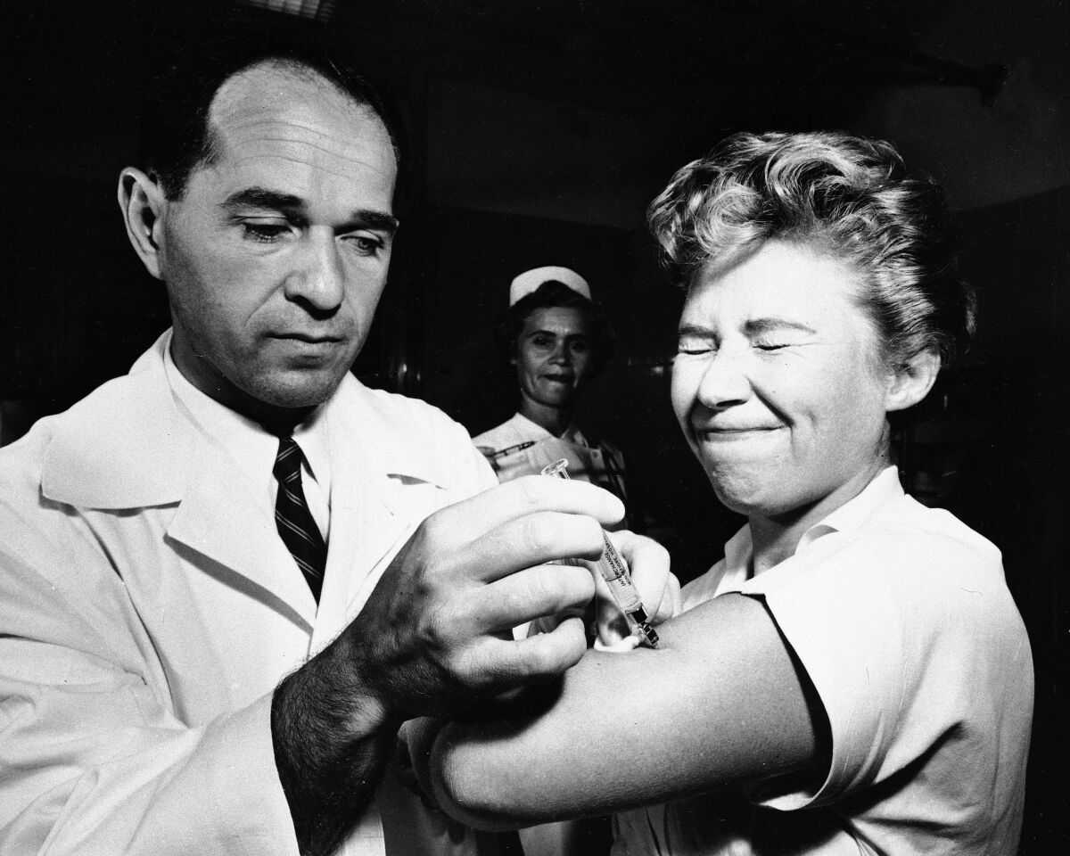 FILE - Dr. Joseph Ballinger giving Marjorie Hill, a nurse at Montefiore Hospital in New York, the first Asian flu vaccine shot to be administered in New York on Aug. 16, 1957. (AP Photo/File)
