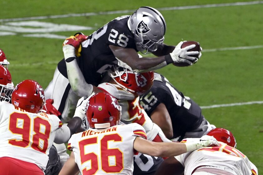 Las Vegas Raiders running back Josh Jacobs (28) attempts to dive over the defending Kansas City Chiefs.