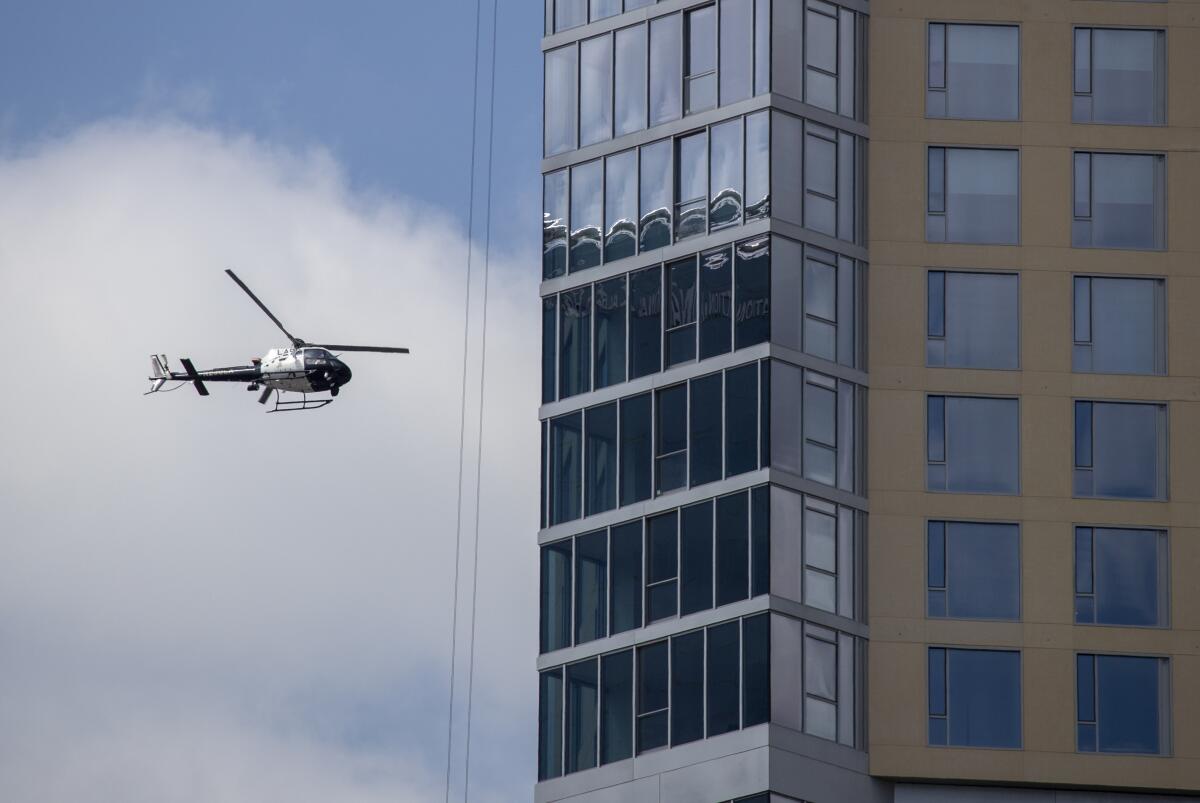 A helicopter flies near a building.