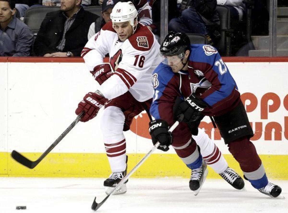 Coyotes defenseman Rusty Klesla fights for possession of the puck against Avalanche right wing Milan Hejduk during the second period of a game last month.