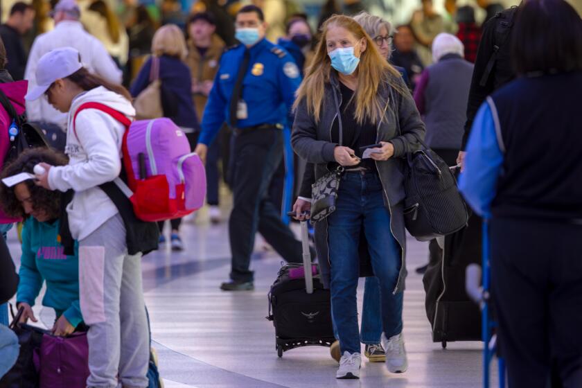 LOS ANGELES, CA - JANUARY 10: Passengers, with and without face mask, at Los Angeles International Airport on Wednesday, Jan. 10, 2024 in Los Angeles, CA. (Irfan Khan / Los Angeles Times)
