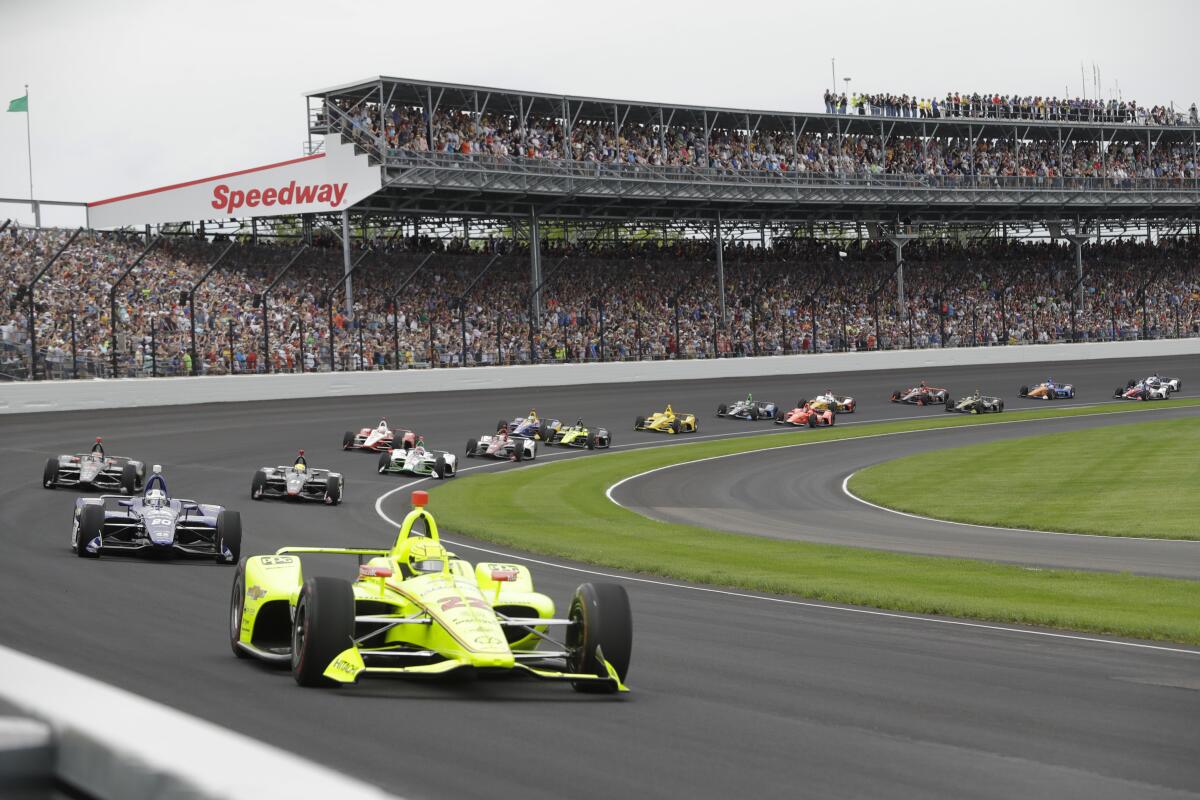 Cars take the first turn at the start of the 2019 Indianapolis 500. This year the fan crowd will be limited to half capacity.