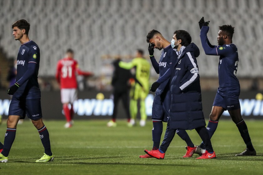 Belenenses' players leave the pitch at the end of the Portuguese Primeira Liga soccer match between Belenenses SAD and SL Benfica, Saturday, Nov. 27, 2021. Belenenses started the match with only nine players due to a coronavirus outbreak. Portuguese health authorities on Monday, Nov. 29, 2021, identified 13 cases of omicron, the new coronavirus variant spreading fast globally, among members of Belenenses SAD. (AP Photo/Pedro Rocha)
