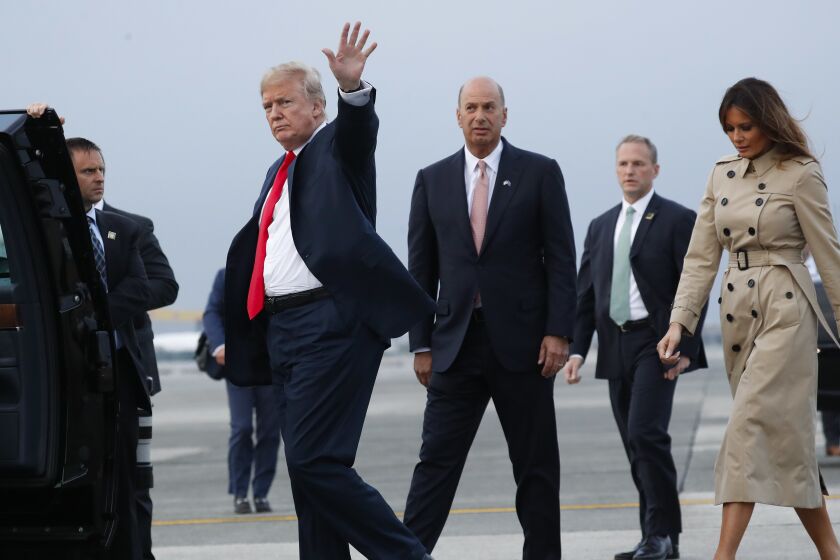 President Donald Trump, left, waves as he walks to his vehicle with Melania Trump, right, during their arrival on Air Force One at Melsbroek Air Base, Tuesday, July 10, 2018 in Brussels, Belgium. Walking with them is Ambassador Gordon D. Sondland, center, U.S. Ambassador to the European Union. (AP Photo/Pablo Martinez Monsivais)