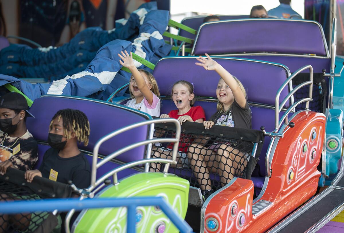 Mackenzie Lockshaw, 8, left, Lily Cox, 9, and Madelyn Lockshaw, 10, ride the Rave Wave Friday at the O.C. Fair. 