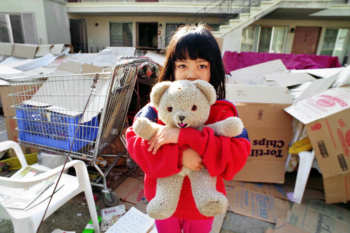 Jessica Hernandez, 7, clutches her teddy bear outside the makeshift shelter where her family and other residents of a Van Nuys apartment complex are living because they are afraid of return to their homes.
