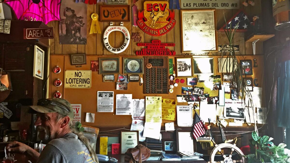 Ron Oxley, a Clamper, has a drink next to the E Clampus Vitus "Wall of Comparative Humbugery" inside the Plumas Club in Quincy, Calif.