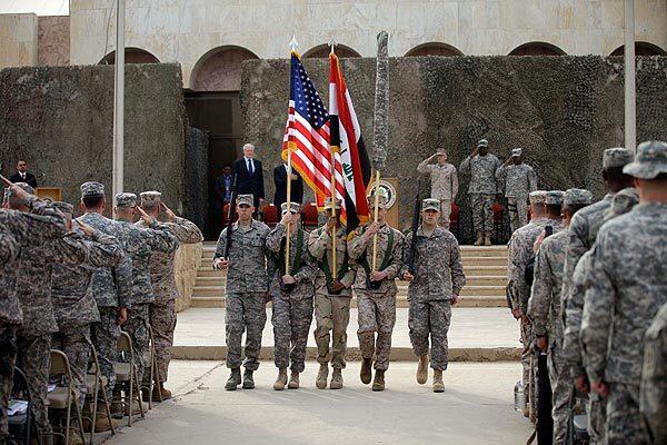 The U.S. and Iraqi flags and the U.S. Forces-Iraq colors are seen before they are carried in during ceremonies in Baghdad marking the end of U.S. military mission in Iraq. After nearly nine years, 4,500 American dead, 32,000 wounded and more than $800 billion, U.S. officials formally shut down a conflict that U.S. Defense Secretary Leon E. Panetta said was worth the price in blood and money, as it set Iraq on a path to democracy.