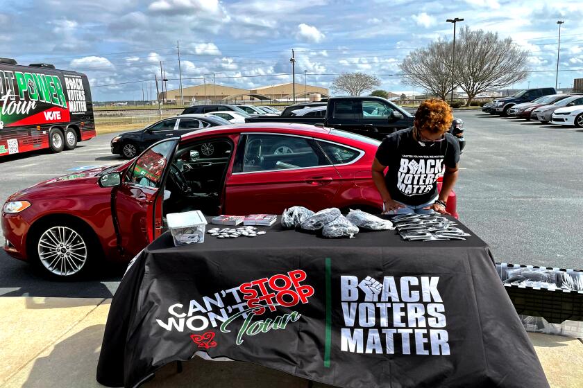 Fenika Miller sets up a table of free Black Voters Matter giveaways