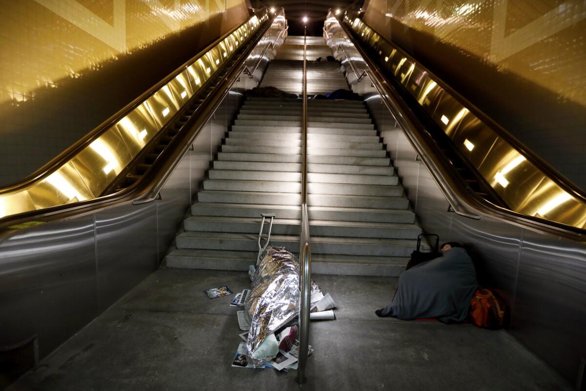 People sleep at the Civic Center/Grand Park Metro Station. (Francine Orr / Los Angeles Times)