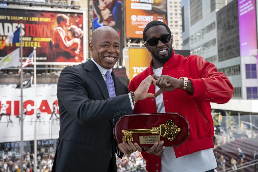 ARCHIVO - Esta foto proporcionada por la Oficina del Alcalde de Nueva York muestra al alcalde Eric Adams, a la izquierda, entregando la llave de la ciudad al artista de hip-hop Sean "Diddy" Combs en Times Square, Nueva York, el viernes 15 de septiembre de 2023. (Oficina del Alcalde de Nueva York/Caroline Rubinstein-Willis vía AP)
