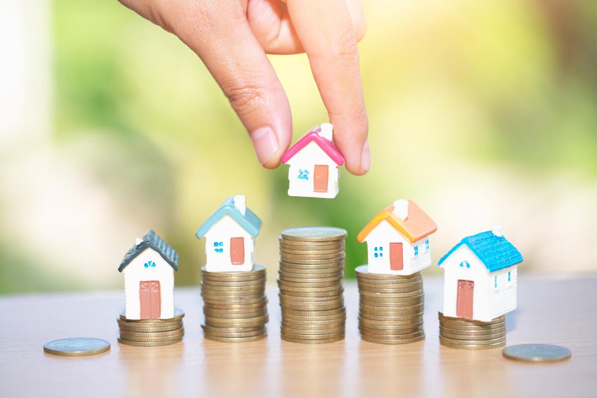 Miniature houses and stacks of coins