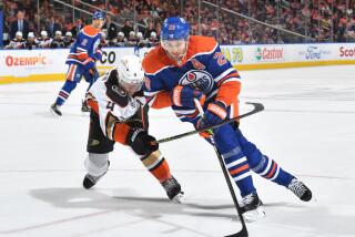 The Oilers' Leon Draisaitl handles the puck against the Ducks' Cam Fowler on April 1, 2023.