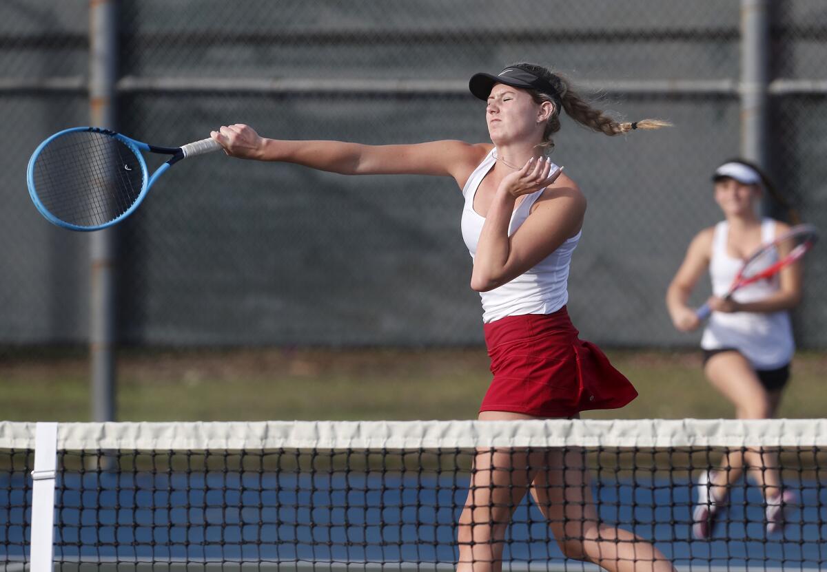 Laguna Beach's Ella Pachl scores at the net as partner Sarah MacCallum, right, looks on in the CIF Southern Section Individuals tournament round of 16 doubles match on Thursday at Lakewood Tennis Center.