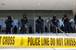 officers in tactical gear with yellow police tape