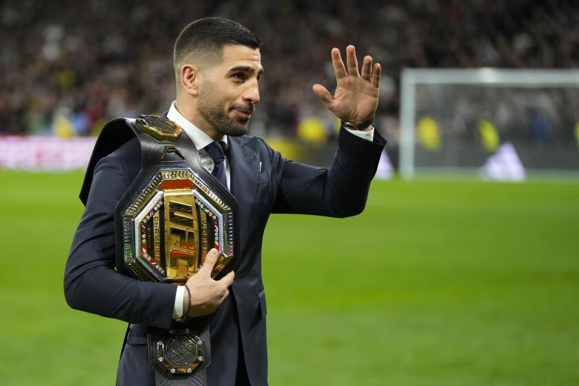 UFC featherweight world champion Ilia Topuria waves as he leaves the pitch after taking the honorary kickoff ahead of the Spanish La Liga soccer match between Real Madrid and Sevilla at the Santiago Bernabeu stadium in Madrid, Spain, Sunday, Feb. 25, 2024. (AP Photo/Manu Fernandez)