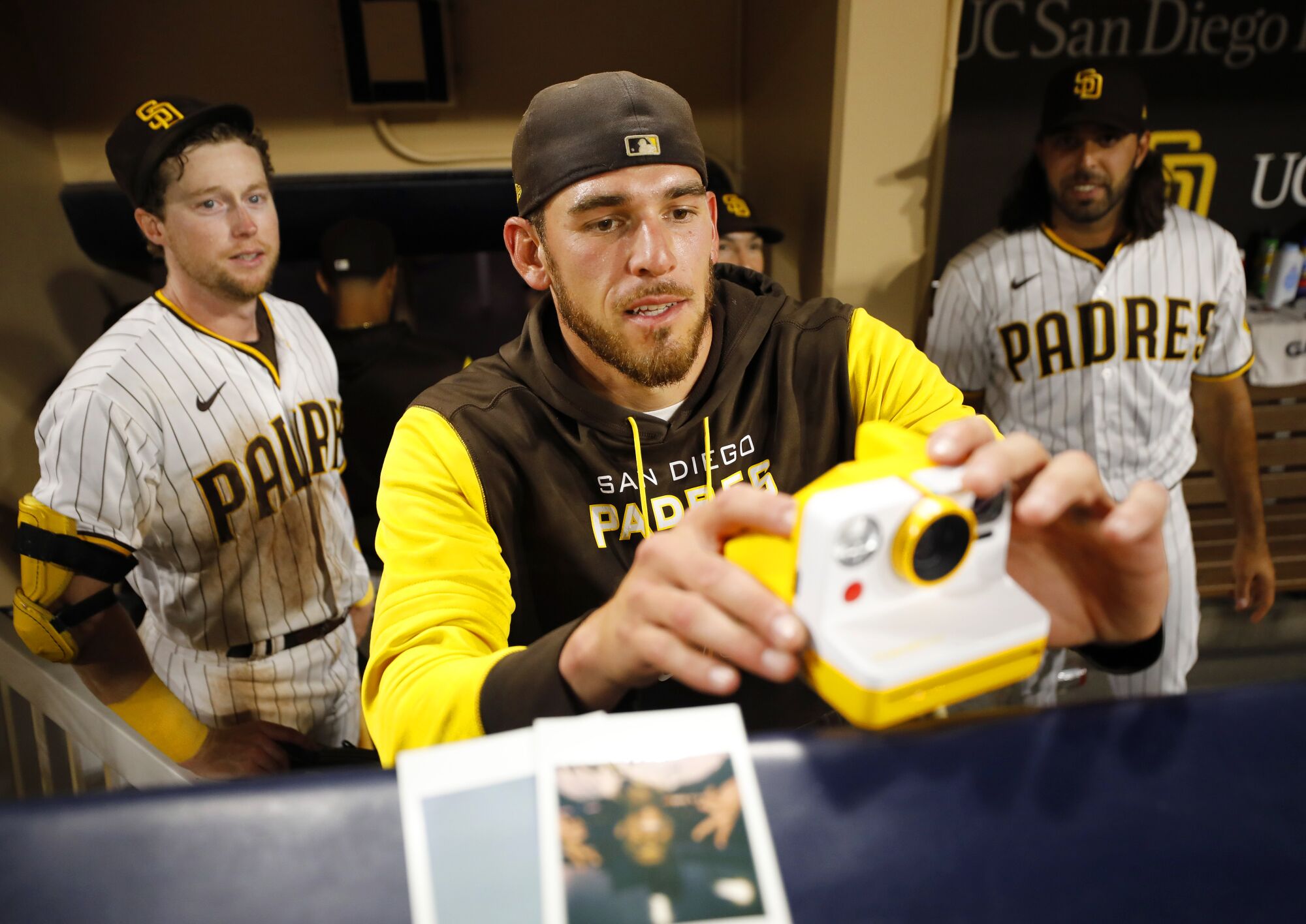 Padres' Joe Musgrove takes a photo with a Polaroid camera of Manny Machado during an interview a