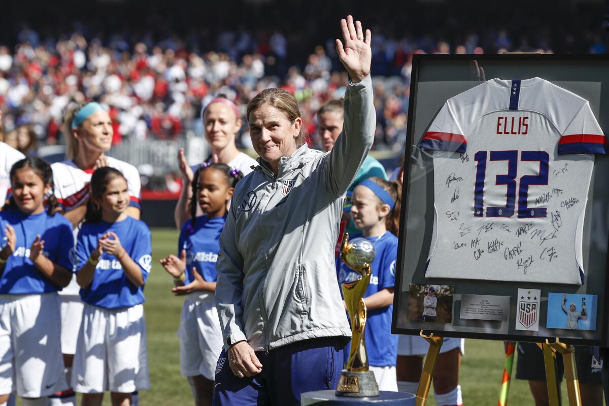 Jill Ellis waves to the crowd as she is honored before a match.