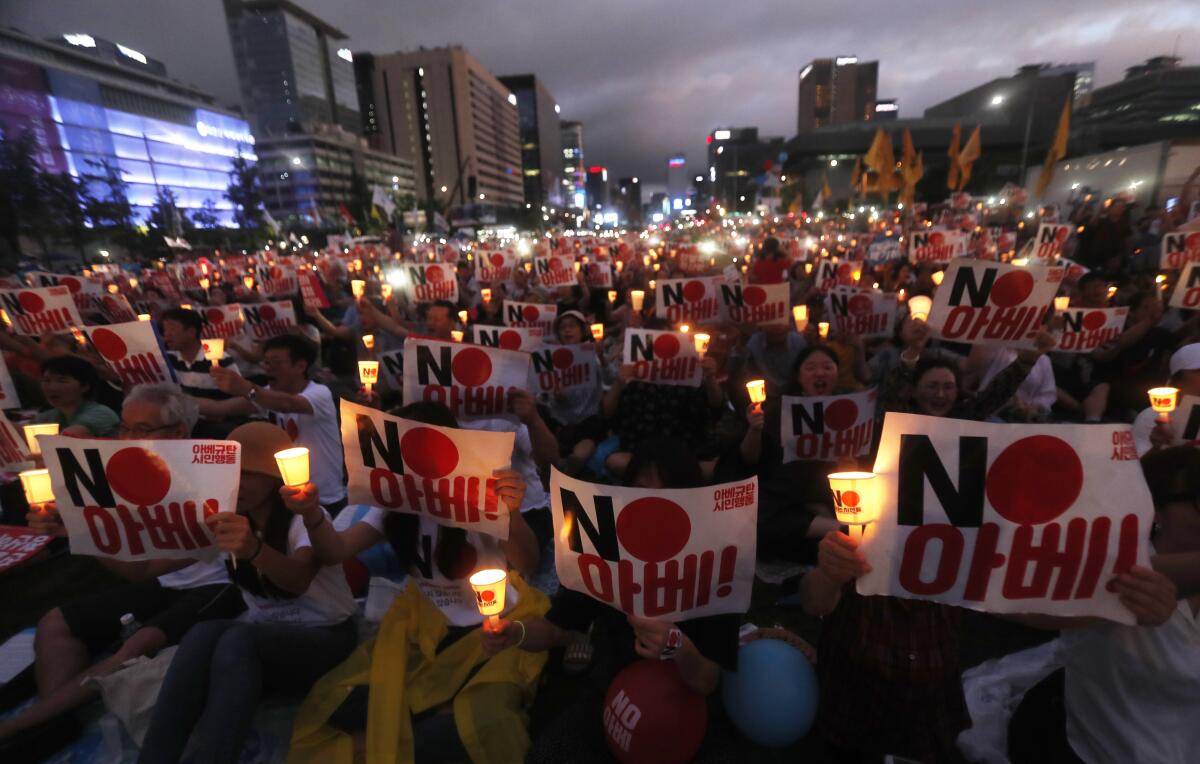 South Korean protesters hold signs that read "No Abe," referring to Japanese Prime Minister Shinzo Abe.