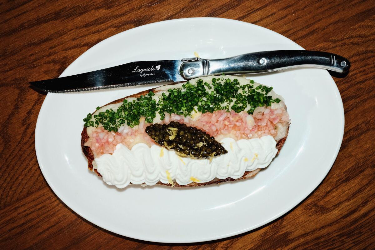 Half a twice-baked potato topped with caviar and lines of chives, shallots and cream at the Benjamin restaurant