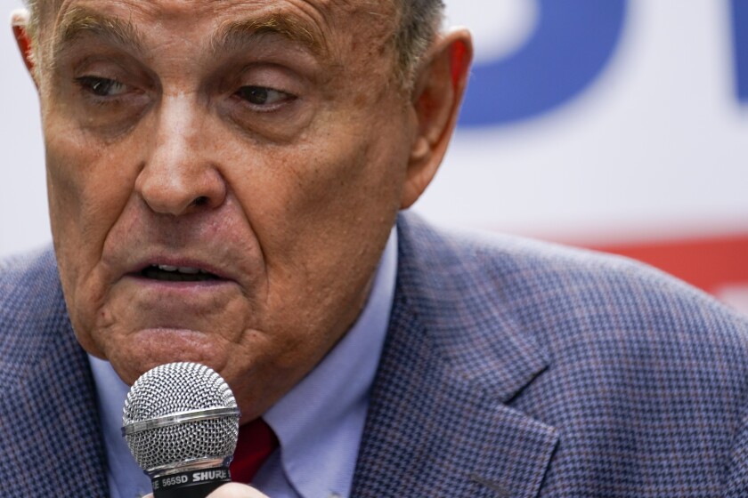 A closeup of Rudy Giuliani speaking into a mic during a campaign event in 2021.