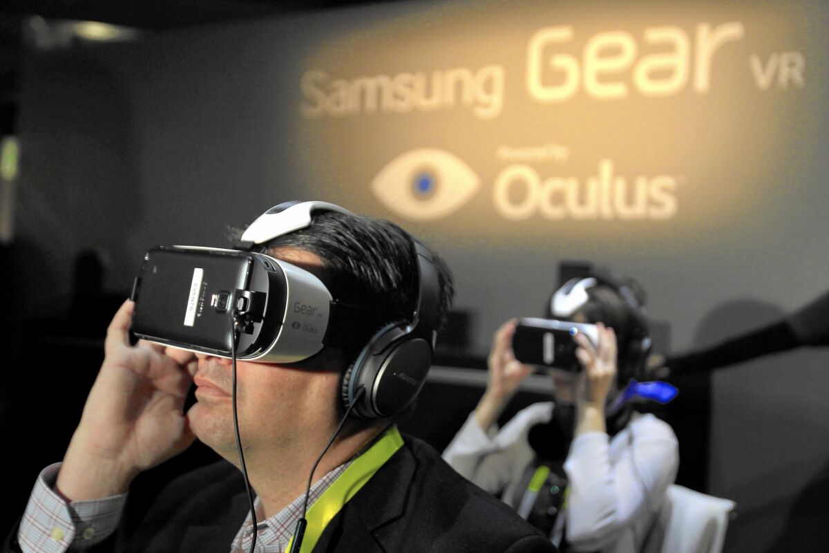 Chris Hall, left, tries out a virtual reality headset during the 2015 International CES in Las Vegas this week.