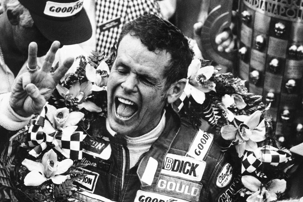 Bobby Unser holds three fingers aloft after winning his third Indianapolis 500.
