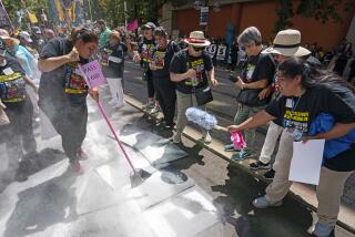 Supporters of a bill to give domestic workers the same safety protections required by by law for other types of employees do a symbolic sweep up outside the Capitol Annex Swing Space office building in Sacramento, Calif., Tuesday, Aug. 29, 2023. The bill, SB686 by state Sen. María Elena Durazo, D-Los Angeles, would give those hired by private employers to do domestic work, protections under the California Occupation Safety and Health Act. (AP Photo/Rich Pedroncelli)