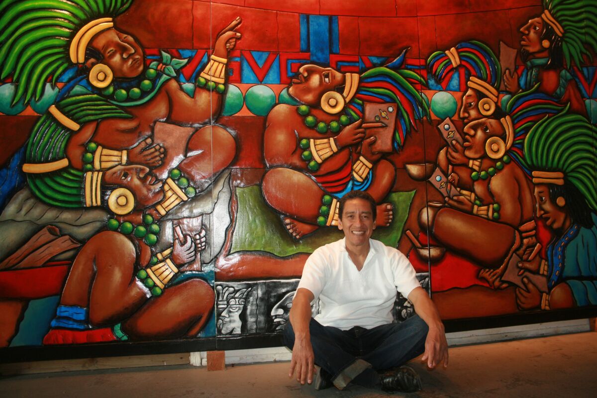 El artista oaxaqueño Mario Sibaja posa junto a su obra de arte denominada “Filósofos, Matemáticos, Observadores, Pensadores…”