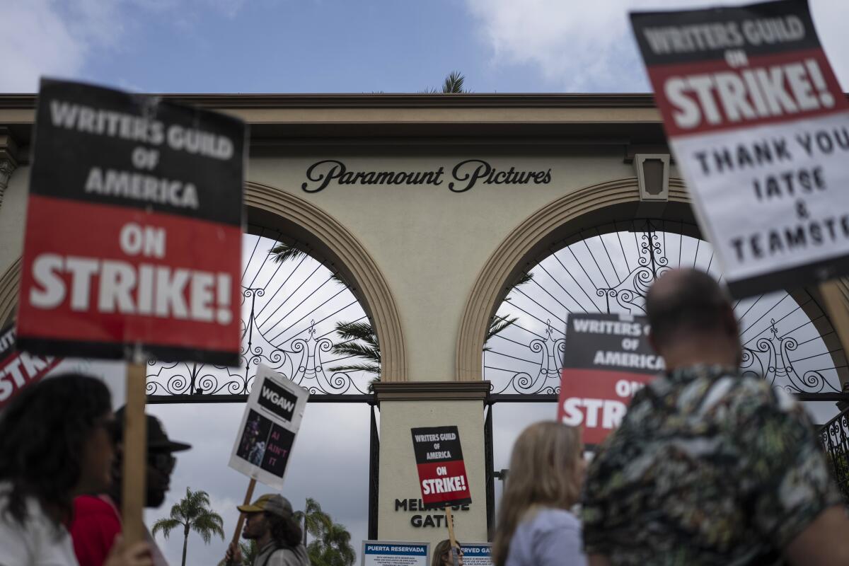 ARCHIVO - Manifestantes con letreros fuera del estudio de Paramount Pictures 