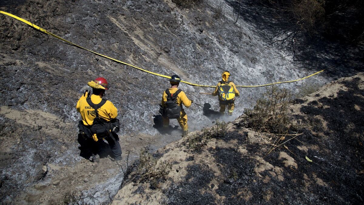 A fire crew from Kern County heads into a ravine to knock out hot spots after the Manzanita fire burned 5,800 acres of rugged terrain.