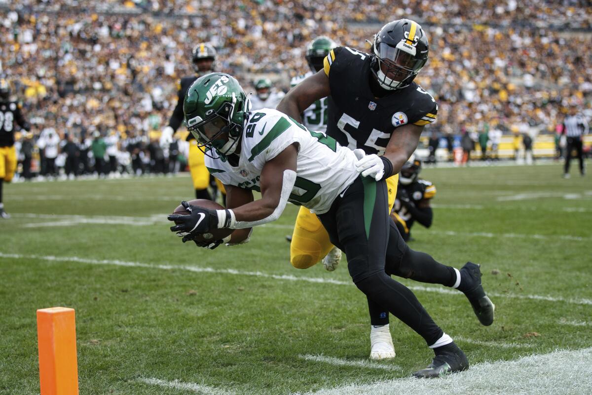 New York Jets running back Breece Hall dives for the end zone in front of Pittsburgh Steelers linebacker Devin Bush.