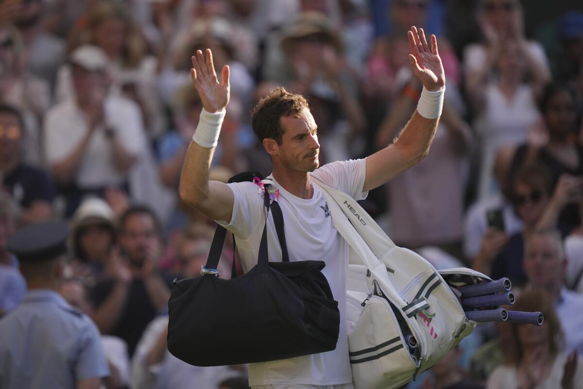 Andy Murray waves to the spectators with both hands as he leaves the court after losing to Stefanos Tsitsipas at Wimbledon.