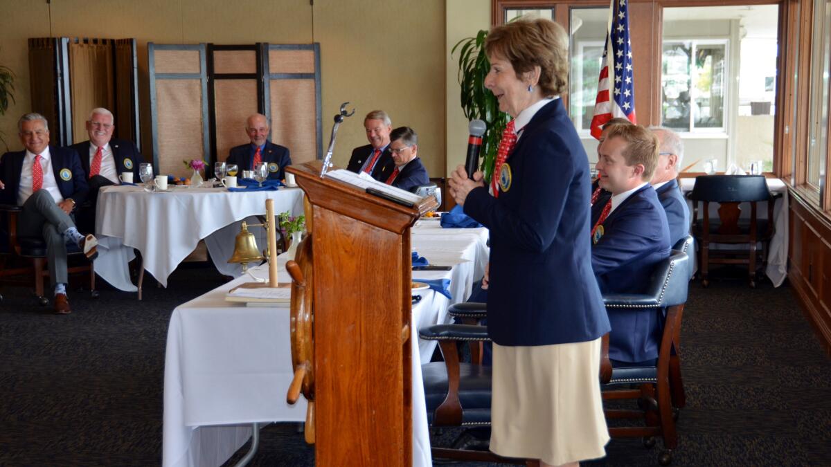 Marie Case, first female skipper of the Commodores Club, Newport Beach, conducts the final meeting of her term Friday.