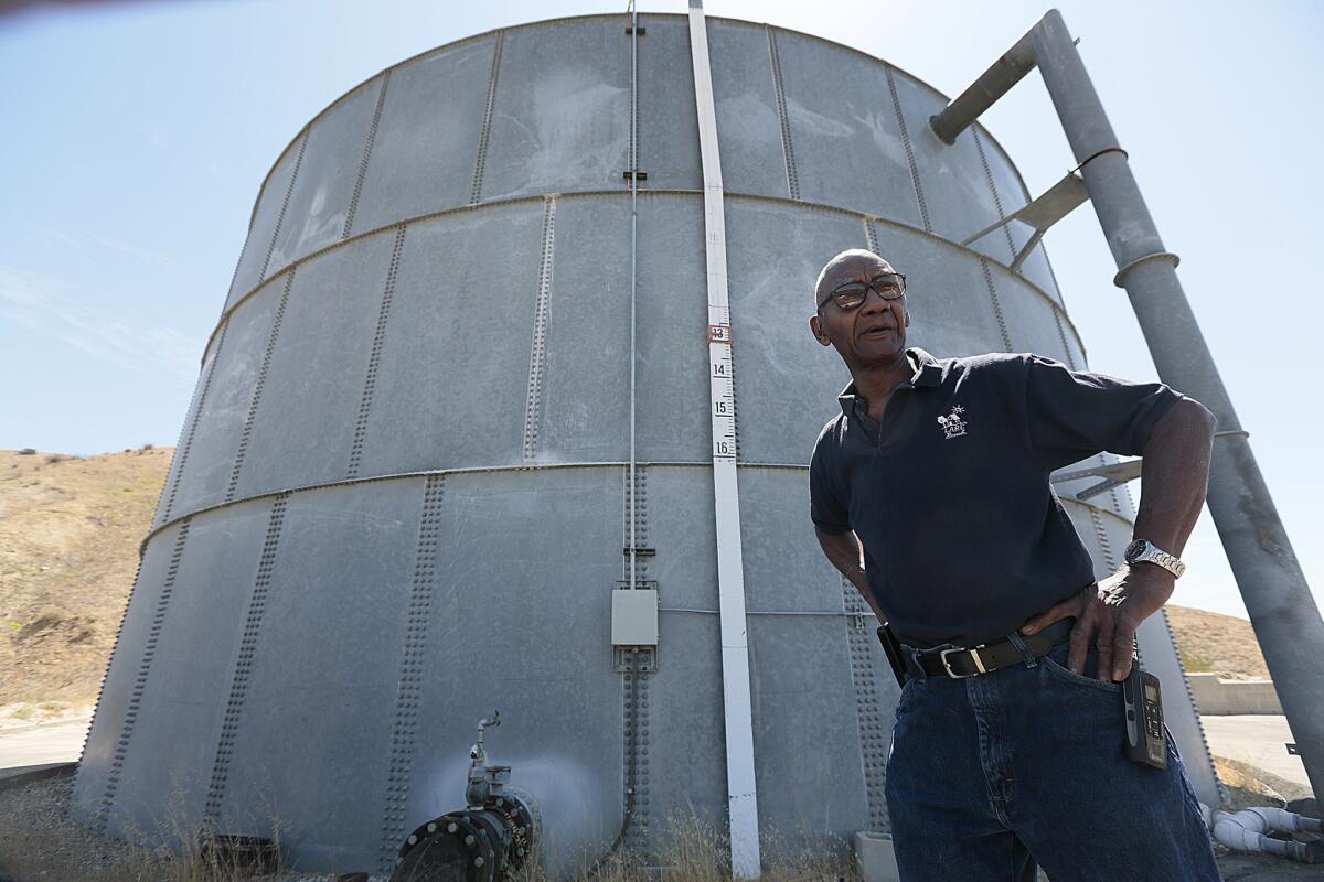 Charles Sturkey, operations director of operations at the Los Angeles Residential Community, stands next to a water tank at the facility, which houses nearly 150 disabled adults. A $500,000 donation from the Annenberg Foundation will keep water flowing at the center while a permanent solution is sought.
