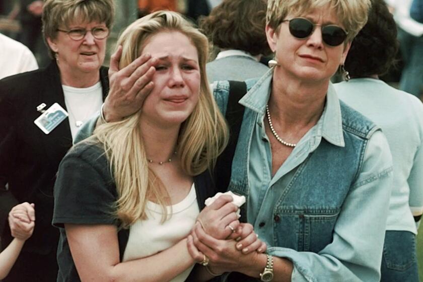 FILE - Fran Allison, right, comforts her daughter, Brooke, after they were reunited following a shooting at Columbine High School in Littleton, Colo., April 20, 1999. Twenty-five years later, The Associated Press is republishing this story about the attack, the product of reporting from more than a dozen AP journalists who conducted interviews in the hours after it happened. The article first appeared on April 22, 1999. (AP Photo/Ed Andrieski, File)