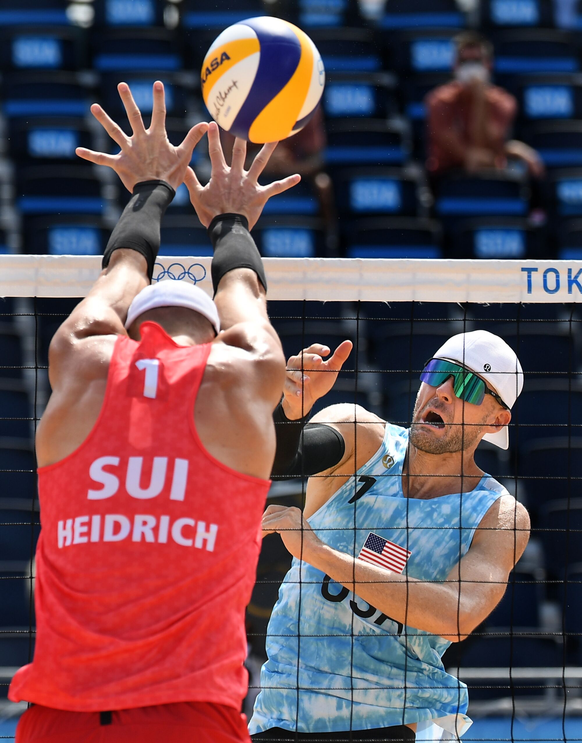 Two men leap at the net.