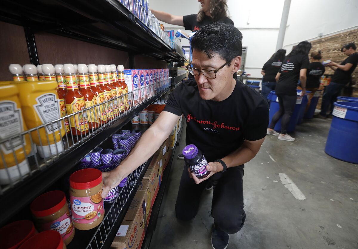 Volunteer Tony Hong organizes peanut butter jars at South County Outreach Food Pantry.