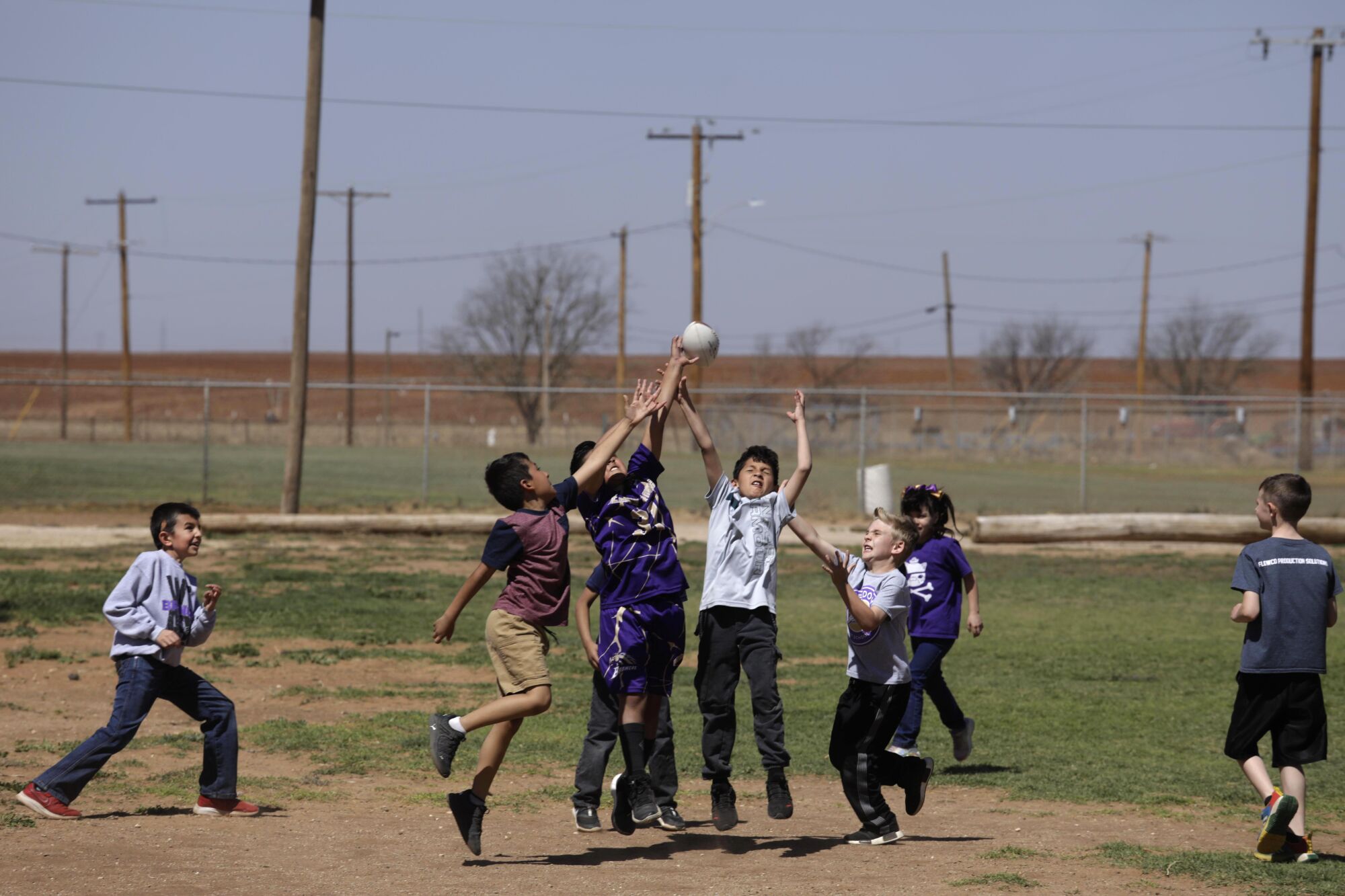 Meadow School students play a game of football during a lunch break recess in Meadow, Texas.