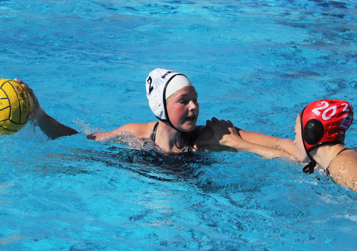 Newport Harbor's Harper Price (2) tries to pass over Orange Lutheran's Kate Sloman (20) during Saturday's action. 
