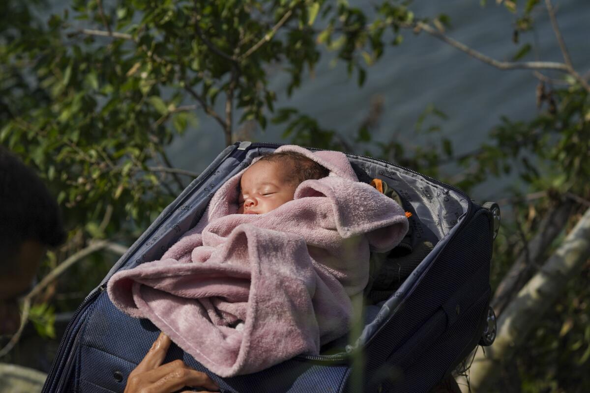 Migrantes cruzan el río Bravo hacia Estados Unidos con un bebé dentro de una maleta abiertaFoto/Fernando Llano)
