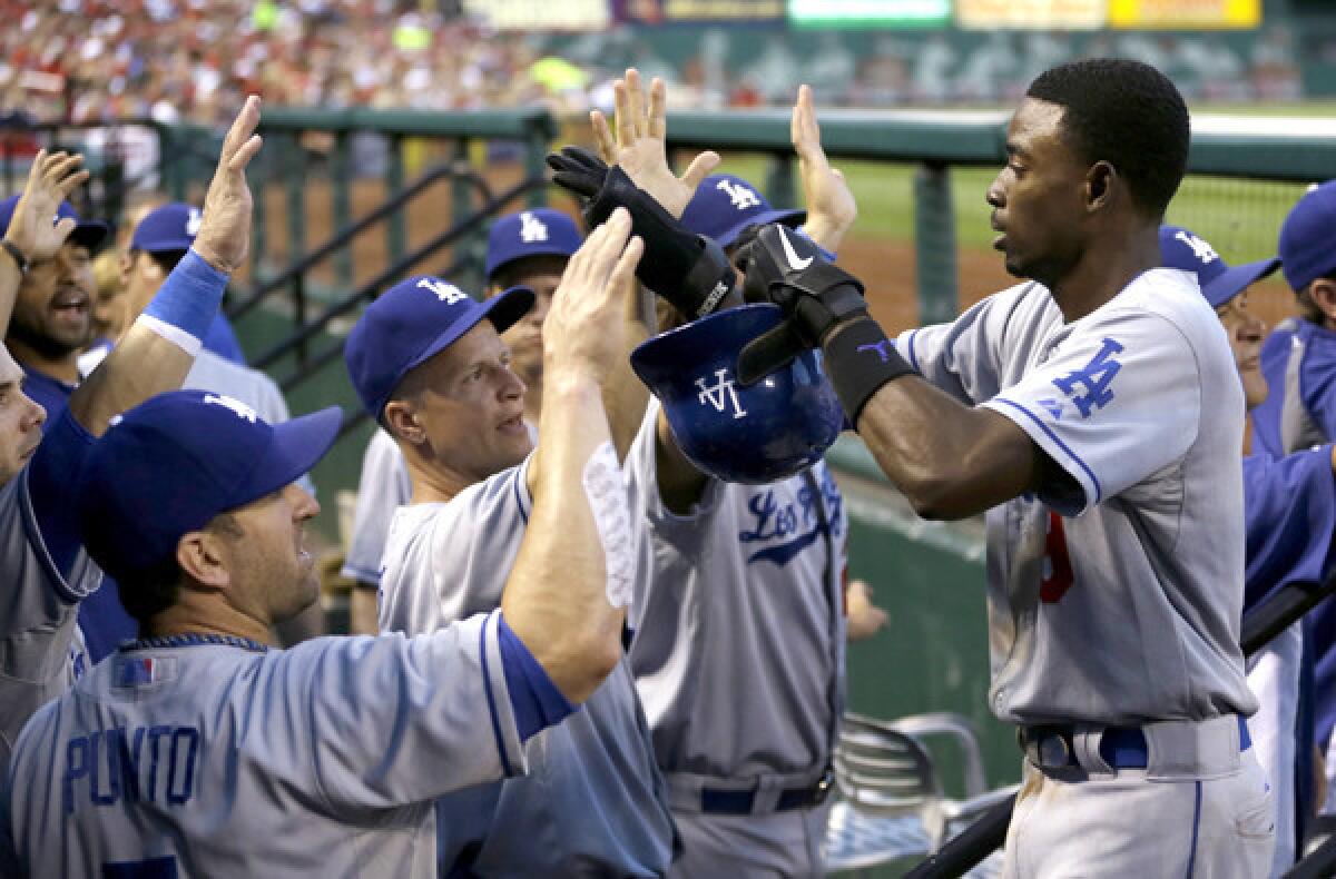 Dodgers shortstop Dee Gordon is congratulated by teammates in the dugout after scoring on single by Jerry Hairston Jr. in the second inning of a game against the St. Louis Cardinals on Wednesday.